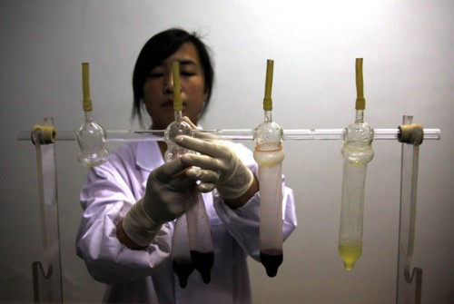 Researcher Wang Tingting gives a demonstration using colored dyes that claims to show how Safedom's condoms prevent the transmission of the Hepatitis B virus at a factory in Zhaoyuan, 100 kilometers south Yantai, in Shandong Province February 6, 2012. 